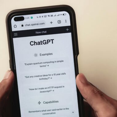 Close-up of hands holding a smartphone displaying the ChatGPT application interface on the screen.