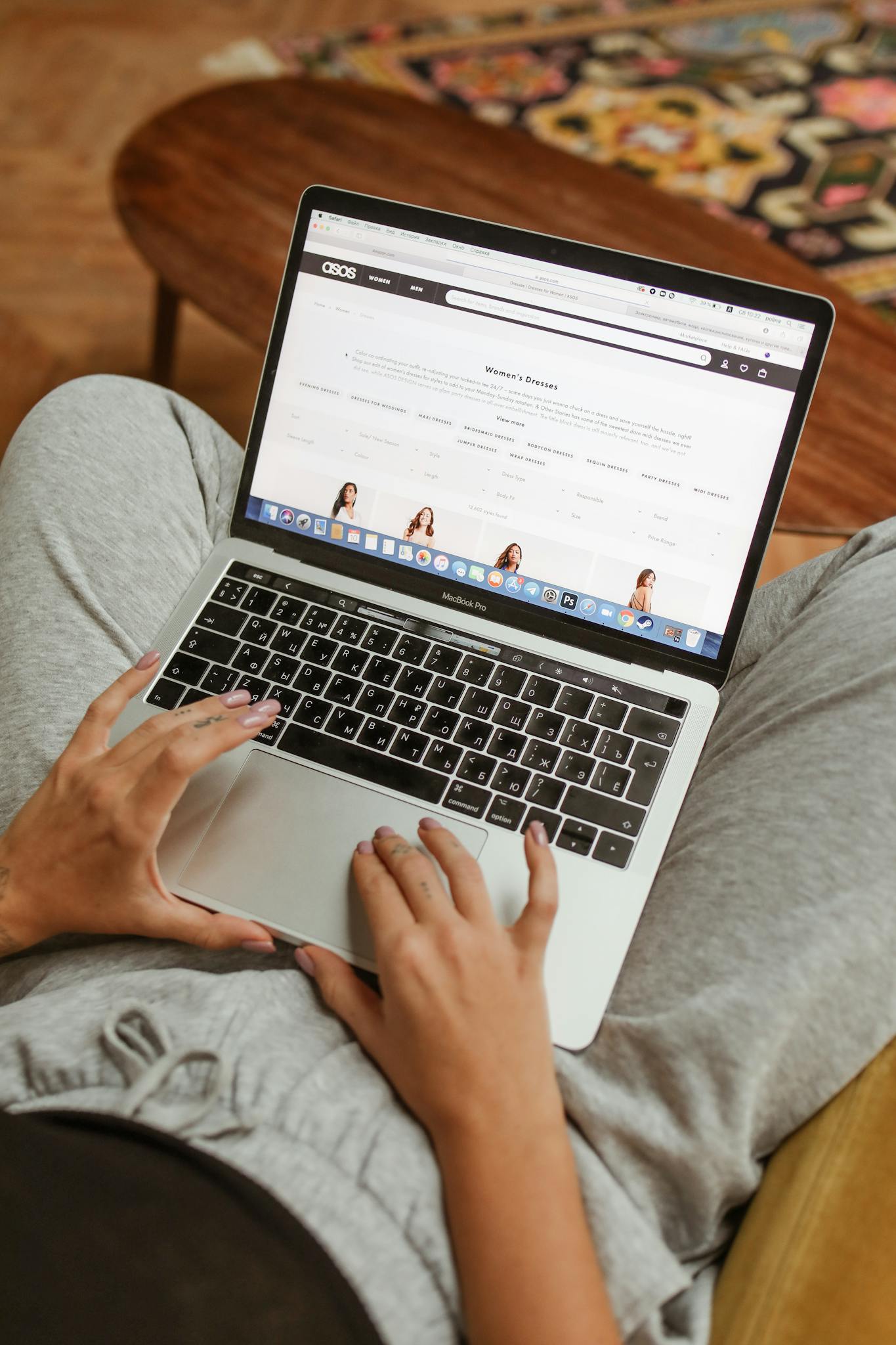 Person browsing an online shopping website on a laptop while relaxing indoors.