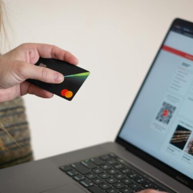 Woman holding credit card while shopping online, showcasing e-commerce convenience.